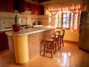 a kitchen with a brick counter and stools at Hospedaje Cattleya in Oxapampa