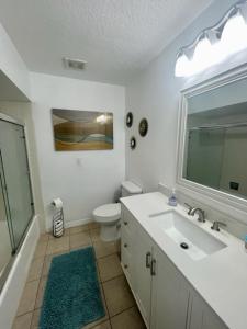 a bathroom with a sink and a toilet and a mirror at Lakefront Duplex With Pontoon Boat Downtown in Mount Dora