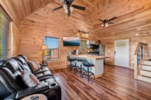 a living room with a leather couch and a bar at Ultimate Summer Escape! Cabin-Hot Tub-Cozy-Views-Minutes2Fun in Sevierville