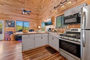 a kitchen with white cabinets and a stove top oven at Ultimate Summer Escape! Cabin-Hot Tub-Cozy-Views-Minutes2Fun in Sevierville