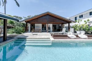 a swimming pool in front of a house at The Seaglass Villa Private Pool and Sauna in Sunshine Beach