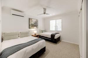 a bedroom with two beds and a window at The Seaglass Villa Private Pool and Sauna in Sunshine Beach +23 photos