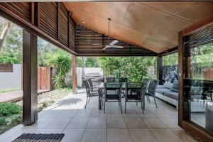 an outdoor patio with a table and chairs at The Seaglass Villa Private Pool and Sauna in Sunshine Beach