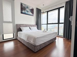 ein Schlafzimmer mit einem großen Bett und großen Fenstern in der Unterkunft Urban Pleasure Suites Central of GeorgeTown Jelutong in Jelutong