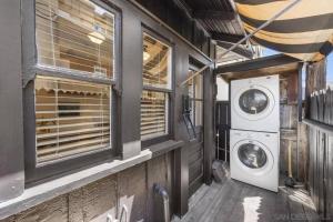 a laundry room with a washing machine and windows at Cute Hillcrest cottage in San Diego