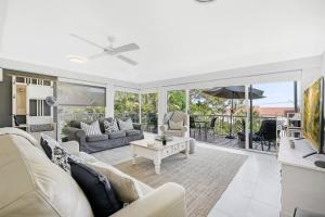 a living room with a couch and a table at Hampton's Style Beach Retreat in Noosa's Heart in Noosa Heads