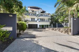 a large white building with a fence in front of a driveway at Hampton's Style Beach Retreat in Noosa's Heart in Noosa Heads
