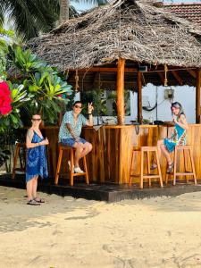 un grupo de personas sentadas en un bar en la playa en Lucky Bay, en Arugam Bay