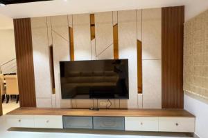 a living room with a large television on a wall at Brand New Luxurious Independent Villa in Hyderabad