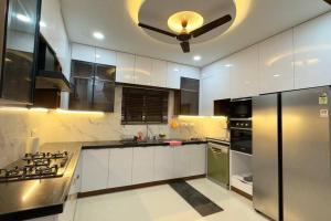 uma cozinha com armários brancos e uma ventoinha de tecto em Brand New Luxurious Independent Villa em Hyderabad