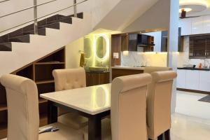 cocina y comedor con mesa y sillas en Brand New Luxurious Independent Villa, en Hyderabad