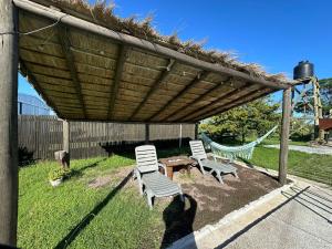 2 sillas y una mesa bajo una pérgola de madera en 0 es 3 Dos en Treinta y Tres