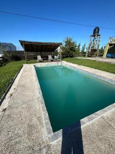 a swimming pool in a yard with a table and chairs at 0 es 3 Dos in Treinta y Tres