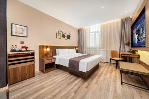 ハルビン市にあるHomeInn Selection Harbin Central Street Sophia Churchのベッドとテレビが備わるホテルルームです。