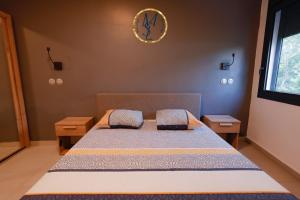 1 dormitorio con 1 cama y reloj en la pared en MSLodge, en Kani Keli