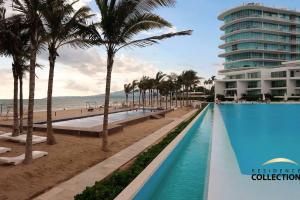 a view of the beach and the pool at the resort at Nuevo Estudio en Aria Ocean 609 in Nuevo Vallarta