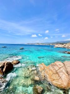 a beach with clear blue water and rocks at THUẬN VƯƠNG Homestay in Vĩnh Hy