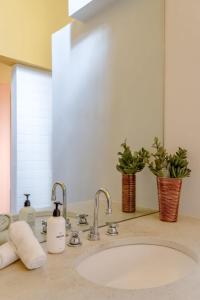 a bathroom sink with two faucets and a mirror at Josh Schweitzer's Monument House Joshua Tree in Joshua Tree +44 photos