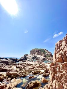 uma vista para uma praia rochosa com o sol no céu em THUẬN VƯƠNG Homestay em Vinh Hy