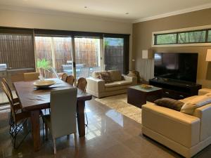 a living room with a dining table and a television at Cowes Luxury Getaway in Cowes