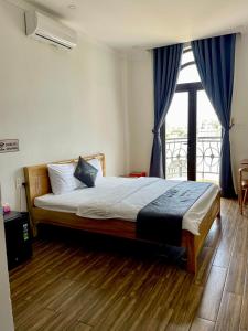a bedroom with a large bed with a window at Hotel Luxstay in Pleiku +44 photos