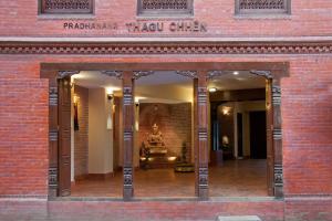 un ingresso a un edificio in mattoni con una statua di Thagu Chhen, a Boutique Hotel a Bhaktapur