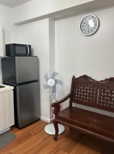 馬尼拉的住宿－Azure Staycation Place，厨房配有冰箱和墙上的时钟