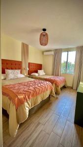1 dormitorio con 2 camas y ventana grande en In & Out Hotel en Guatemala
