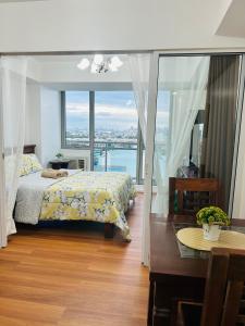 a bedroom with a bed and a table and a window at Azure Staycation Place in Manila