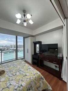 馬尼拉的住宿－Azure Staycation Place，一间卧室配有一张床、一张书桌和一个窗户。