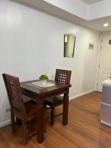 馬尼拉的住宿－Azure Staycation Place，一间带桌子和两把椅子的用餐室