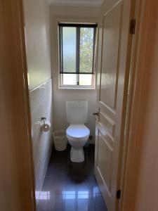a small bathroom with a toilet and a window at Cowes Luxury Getaway in Cowes +23 photos