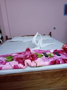 a bed with a pink blanket and remote controls on it at Hotel Chemistrica Digha - Couple Friendly - Best Location in Digha