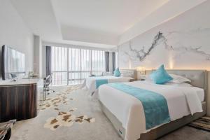 a hotel room with two beds and a sink at Huaqiang Plaza Hotel Shenzhen, Enjoy Complimentary Mini Bar & Night Snack, Add breakfast - enjoy complimentary afternoon tea in Shenzhen