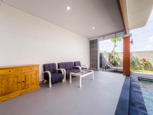 sala de estar con sofá y mesa en Yuta Villa Ubud, en Ubud