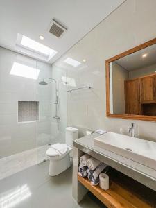 y baño con aseo, lavabo y ducha. en Yuta Villa Ubud, en Ubud