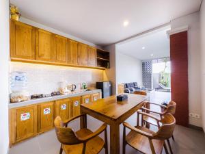 una cocina con armarios de madera y una mesa y sillas de madera. en Yuta Villa Ubud, en Ubud