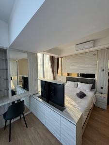um quarto com uma cama grande e uma televisão. em Pollux High Rise Apartments at Batam Center with Netflix by MESA em Batam Center