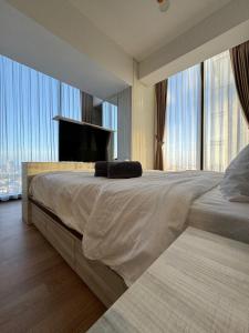 a bedroom with a large bed with large windows at Pollux High Rise Apartments at Batam Center with Netflix by MESA in Batam Center