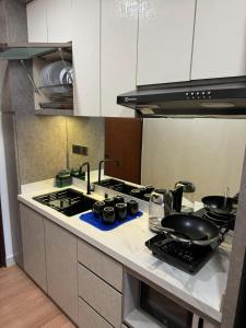 a kitchen with a stove and a counter top at Pollux High Rise Apartments at Batam Center with Netflix by MESA in Batam Center