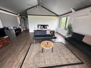 a living room with a couch and a table at Wallaby Lodges in Pokolbin