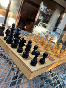 a wooden chess board with black chess pieces on it at Cabaña de descanso "El Tigre" in Quiroga