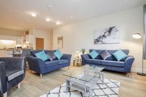 a living room with two blue couches and a table at Luxury Apartments 2 Bedrooms Central Maidenhead in Maidenhead