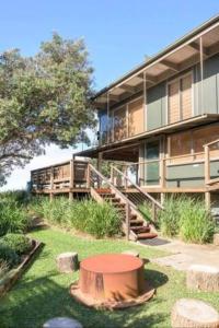 a building with a tree stump in front of it at One Hundred Banksias in Culburra Beach