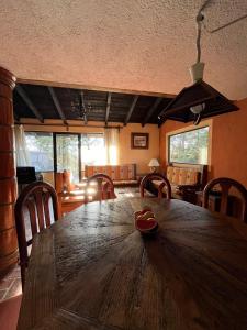 a dining room with a wooden table and chairs at Cabaña de descanso "El Tigre" in Quiroga