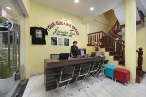 a woman sitting at a desk with two laptops at Hanoi Backpackers Hostel Oldtown in Hanoi