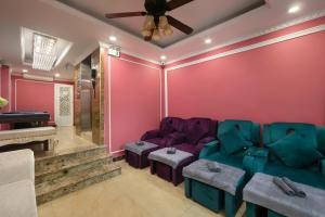 a living room with pink walls and purple furniture at Hanoi Backpackers Hostel Oldtown in Hanoi
