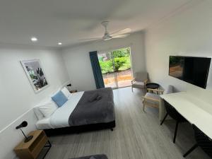 a bedroom with a bed and a desk and a television at Mareeba Motor Inn in Mareeba