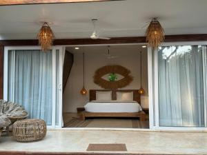 a bedroom with a bed and a large window at Thalassa Beach Boutique Resort in Goa Velha