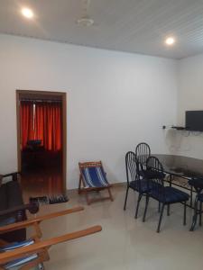 a living room with a table and chairs and a desk at Oasis villa in Vagamon